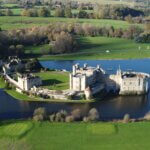 Aerial view of Caerphi Castle, a historic medieval structure situated above a tranquil lake