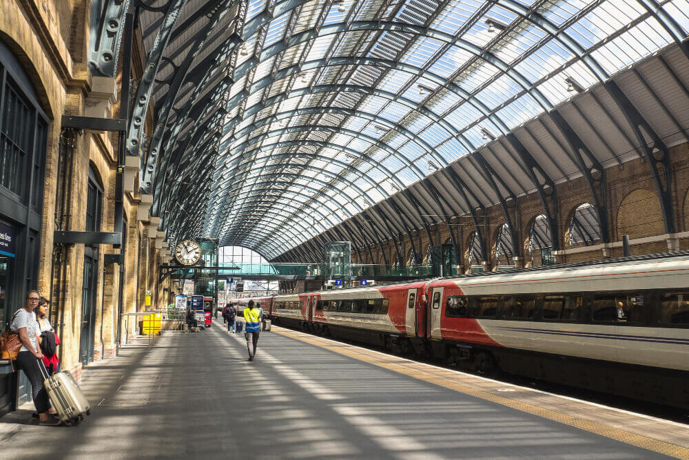 The domed concourse at King's Cross St Pancras station with travellers crossing beneath the white lattice roof