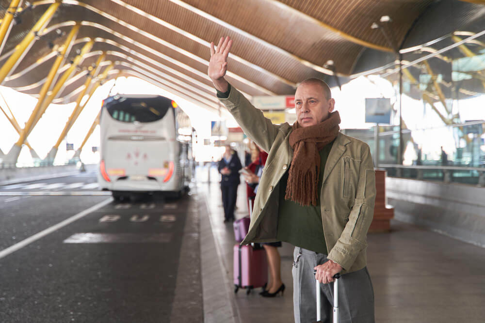 Traveller reviewing transport options at Gatwick Airport departure board before journey to Birmingham